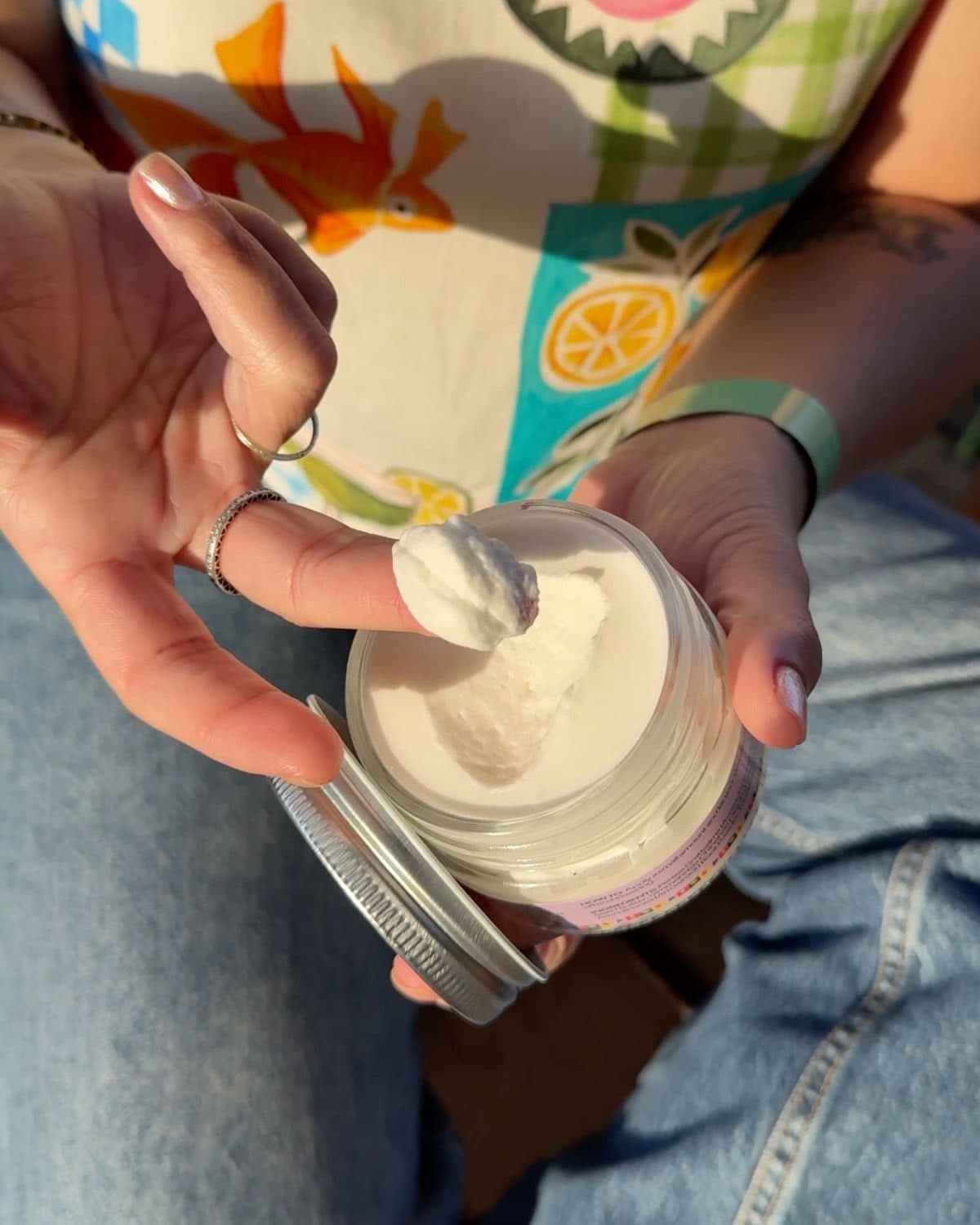 Natalie Picanco scooping Manna body butter from an open jar