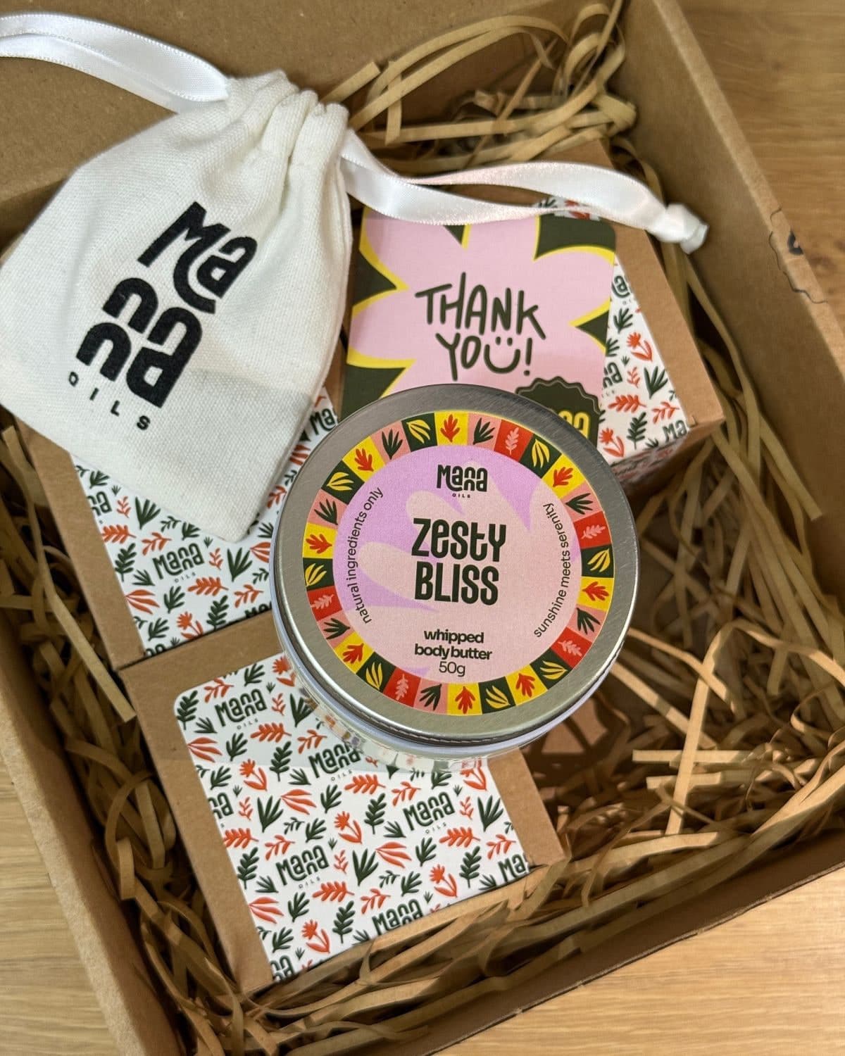 Open Manna Oils delivery box with Zesty Bliss body butter and pouch