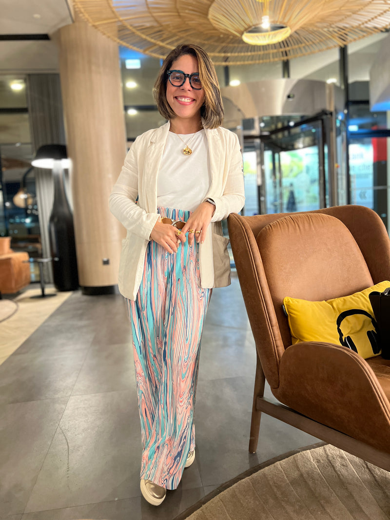 Miriam Souza, CEO and founder of Manna Oils, standing in a modern workspace — representing conscious leadership and natural skincare innovation.